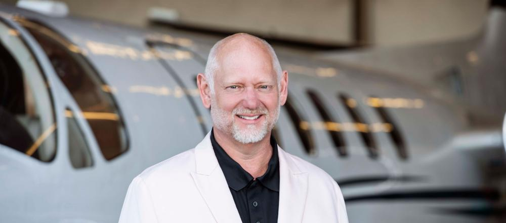 Erik Weir in front of a private jet
